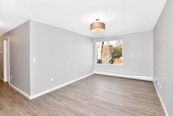 an empty living room with white walls and a window at Springwood Gardens, New Britain, Connecticut